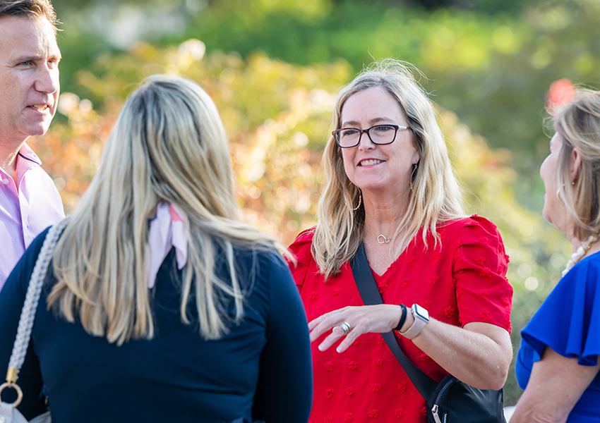 Lady in red shirt talking to group.