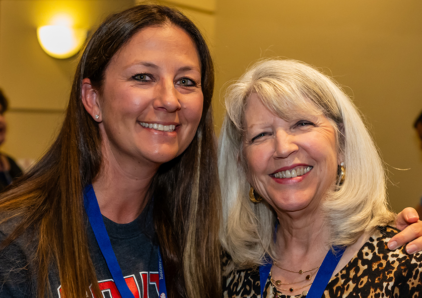 Two alumni smiling.