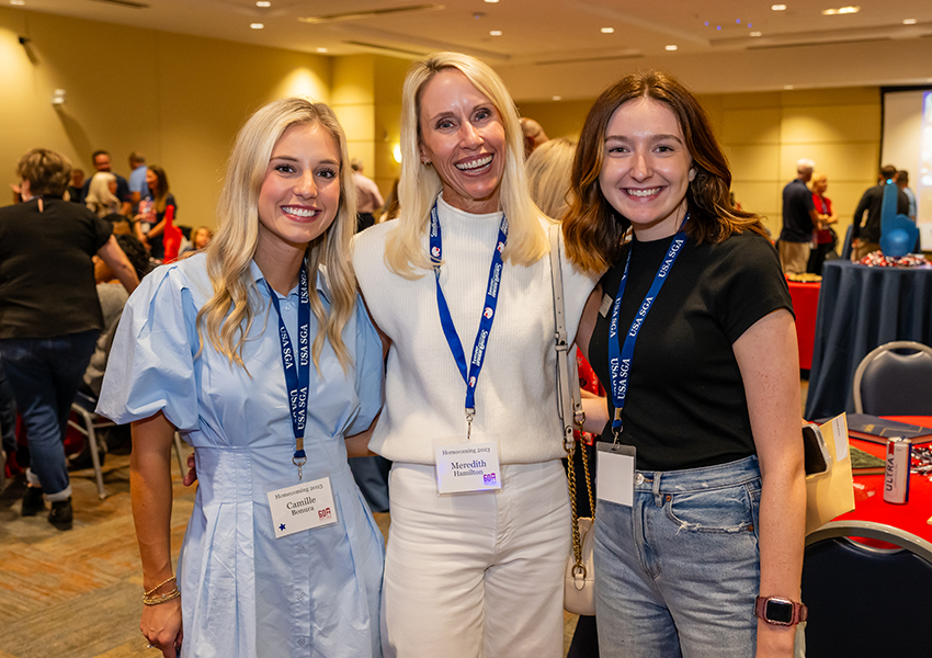 Three alumni smiling.