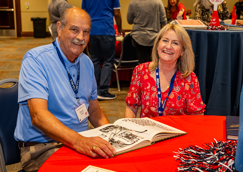 Two alumni smiling.