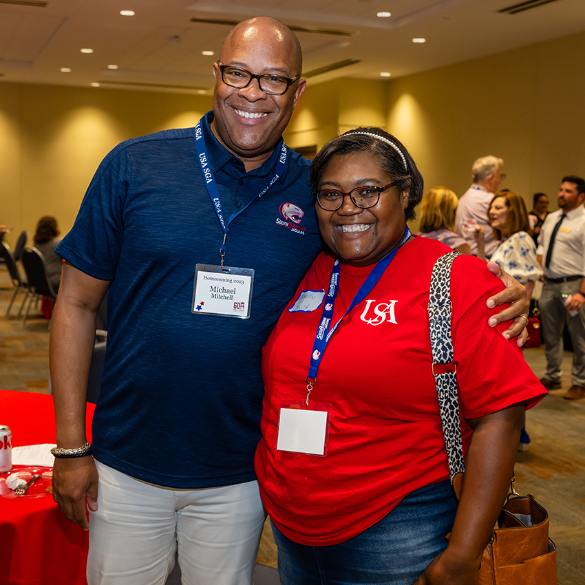 Two alumni smiling.