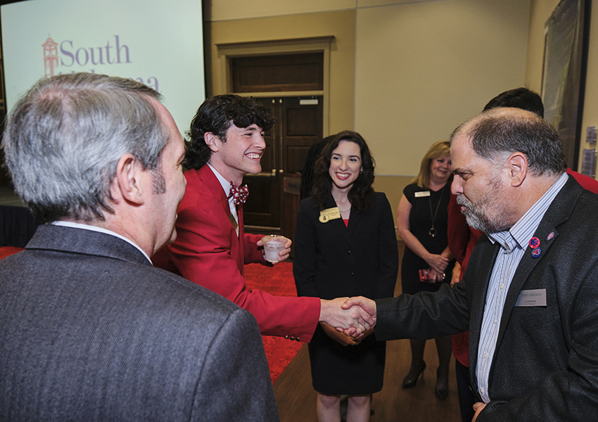 Two alumni greeting each other.