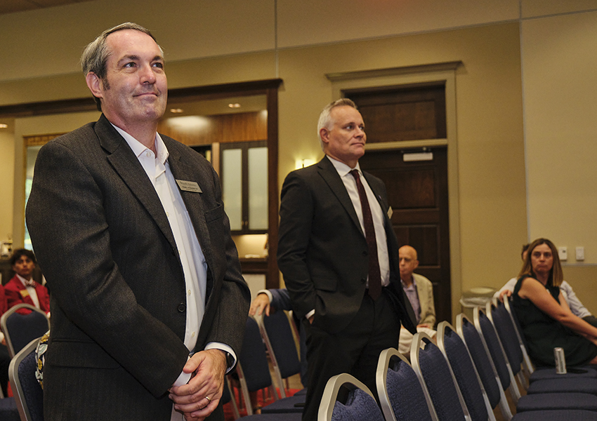 Two alumni watching a presentation.