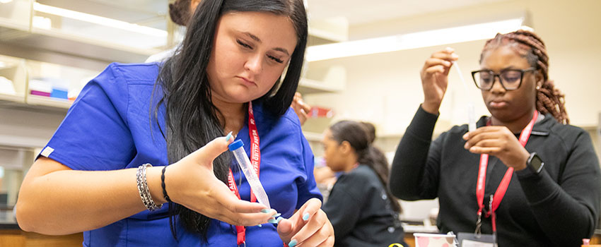 Students working with syringes in classroom.