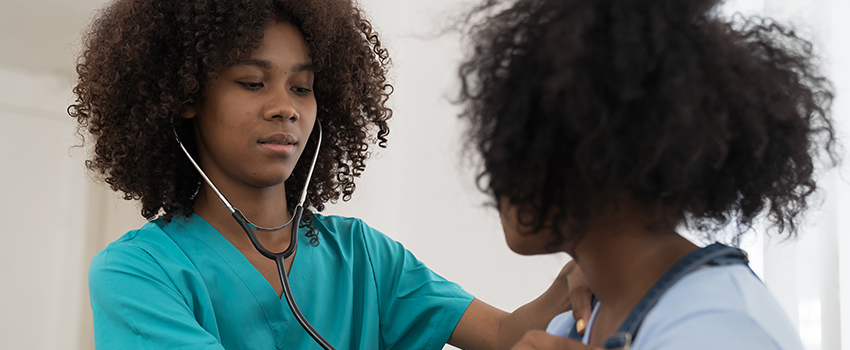 Nurse checking patient with stethoscope. 