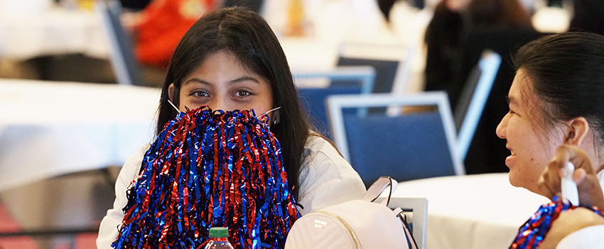 High school student with shaker in front of her face.