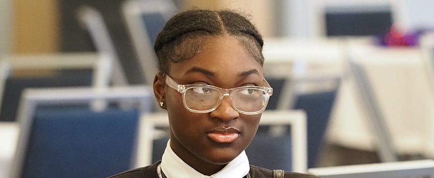Student in glasses at table.