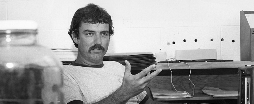 Old black and white photo of Dr. Shipp sitting in a lab talking.