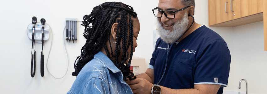 Dr. Hamayun Imran examines sickle cell patient in exam room.