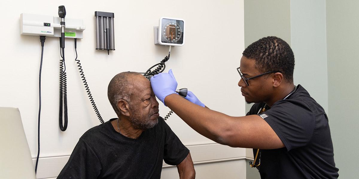 Physician examines a senior, male patient.