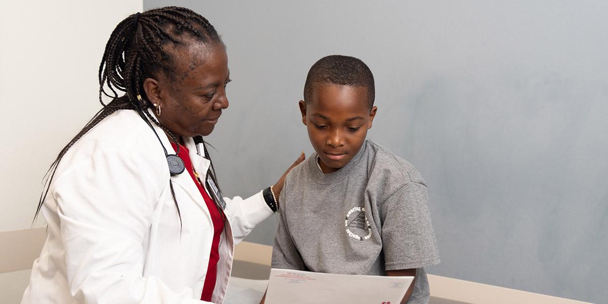 Nurse practitioner examines a young, male patient.