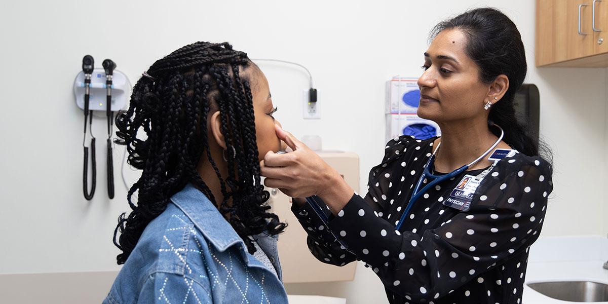 Dr. Preethi Marri examines sickle cell patient in exam room.