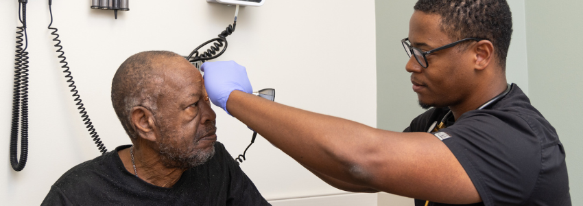 Physician examines a senior, male patient.