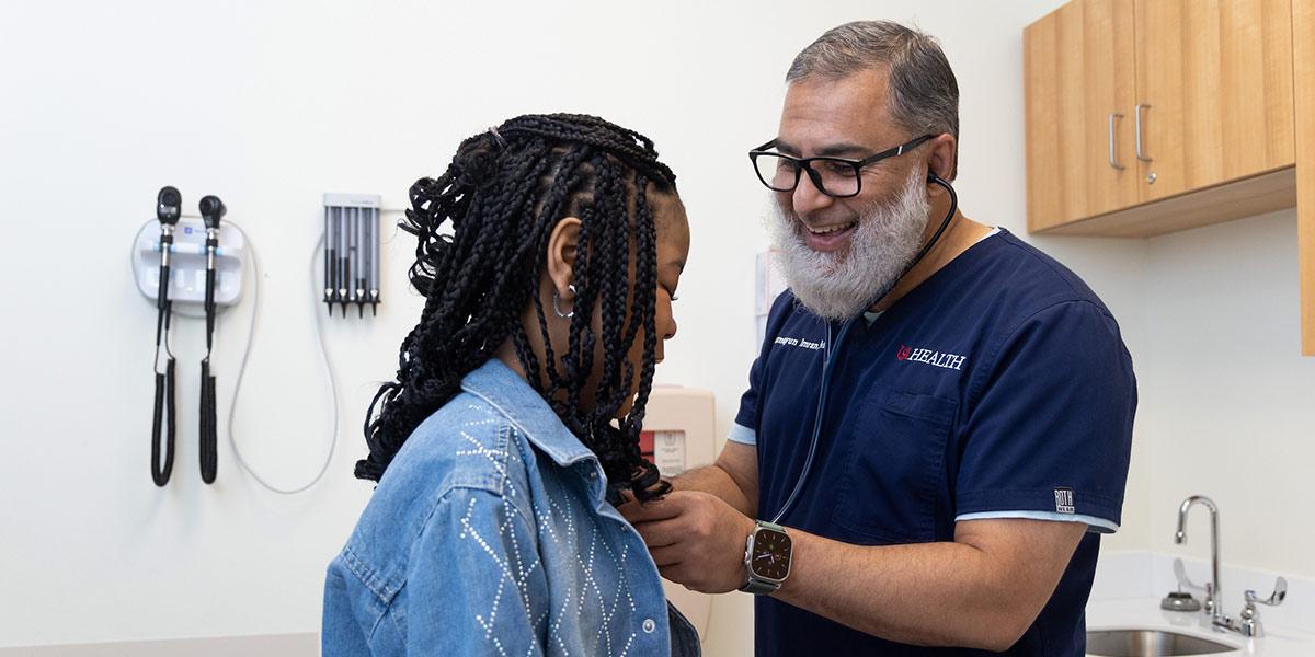 Dr. Hamayun Imran examines sickle cell patient in exam room.