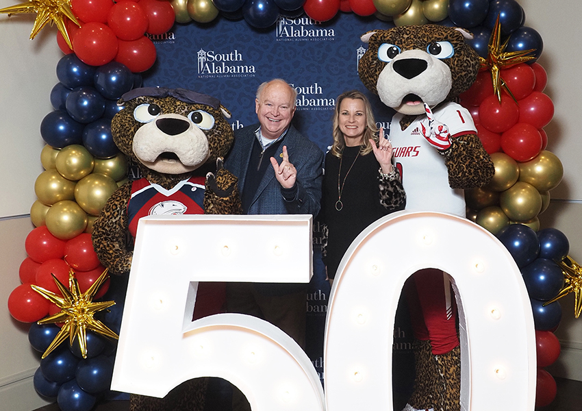 South Alabama's President Joe Bonner with South Alumni posing behind the "50" beside Ms. Paula and South Paw