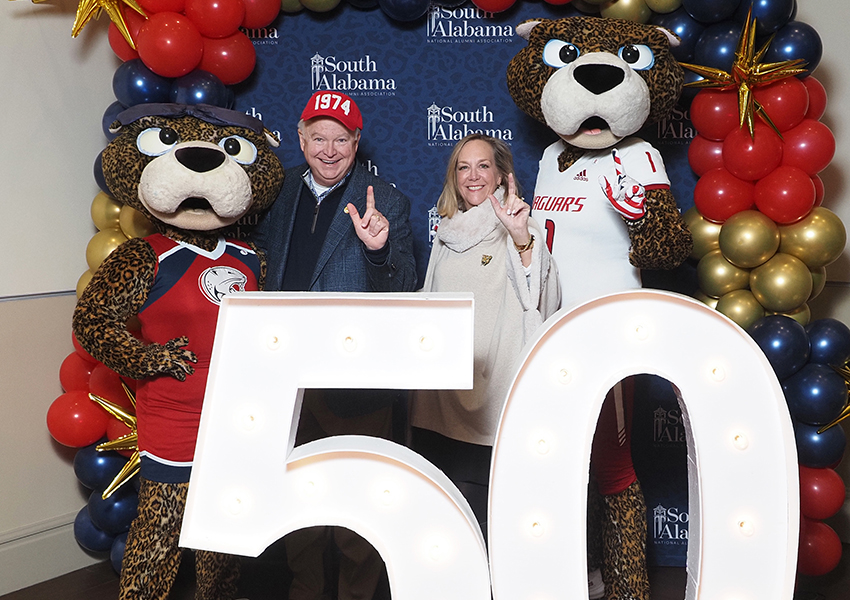 South Alabama's President Joe Bonner with his wife pose behind the "50" beside Ms. Paula and South Paw