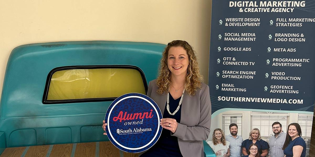 Southern View Media owner holding up Alumni owned sign