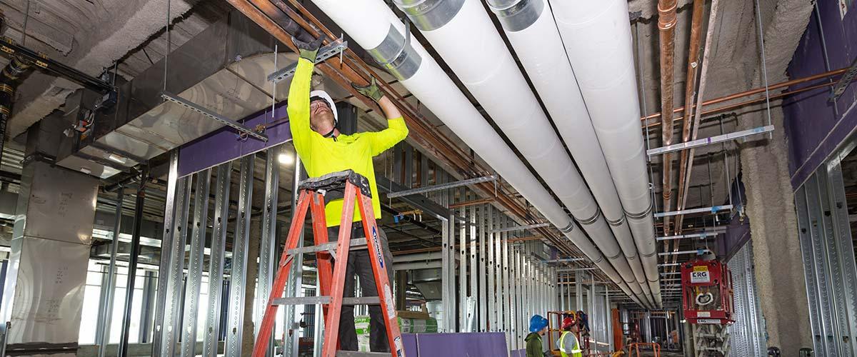 Worker at job site on ladder