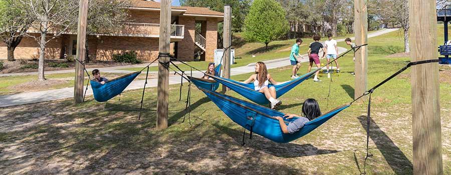 South students laying in hammocks on campus.