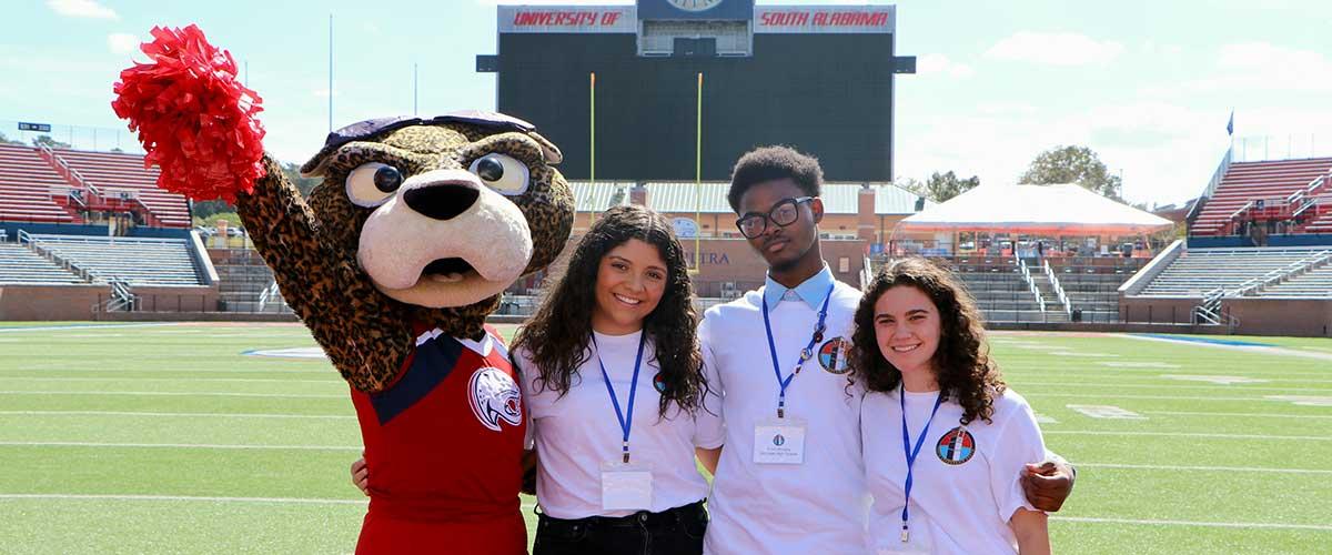 Students with Miss Paula in Hancock Whitney Stadium