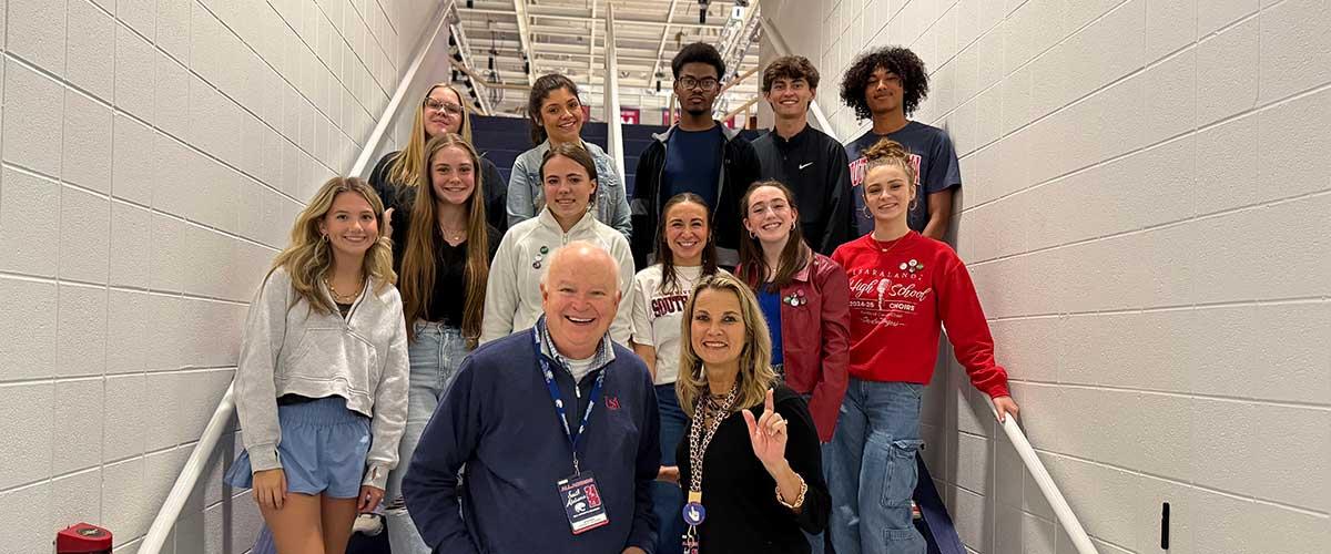 Students taking a picture with Joe Bonner the University of South Alabama President at the basketball game