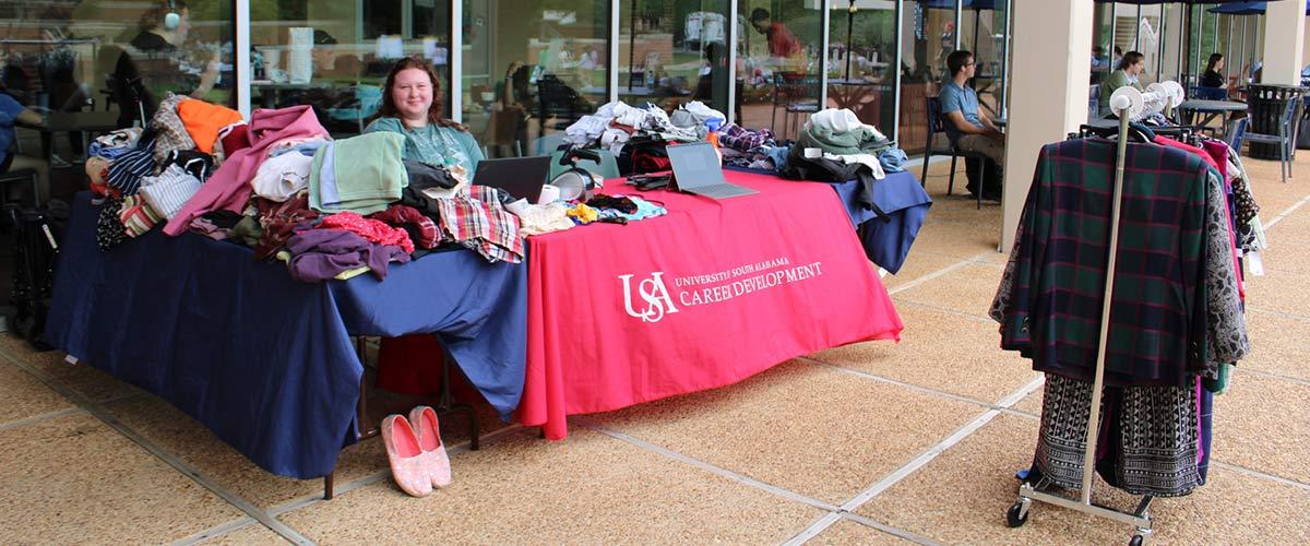 Person behind table at clothing drive.
