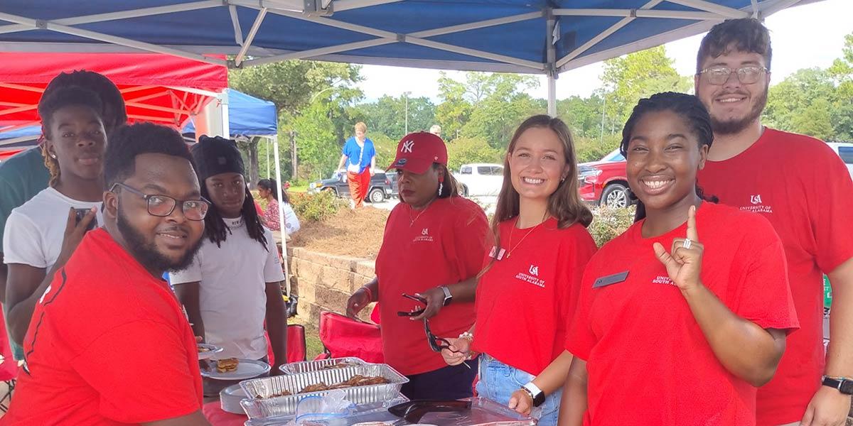 CEPS Ambassadors eating at tailgate tent.