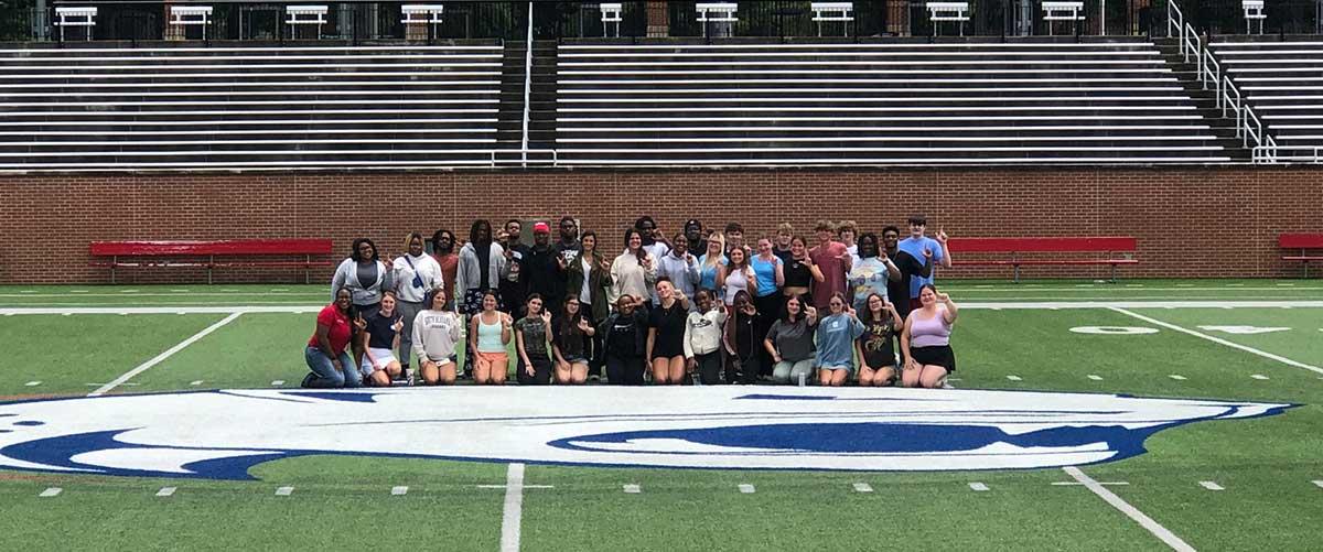 South Alabama Students throwing up "the J" on South Alabama's soccer field.