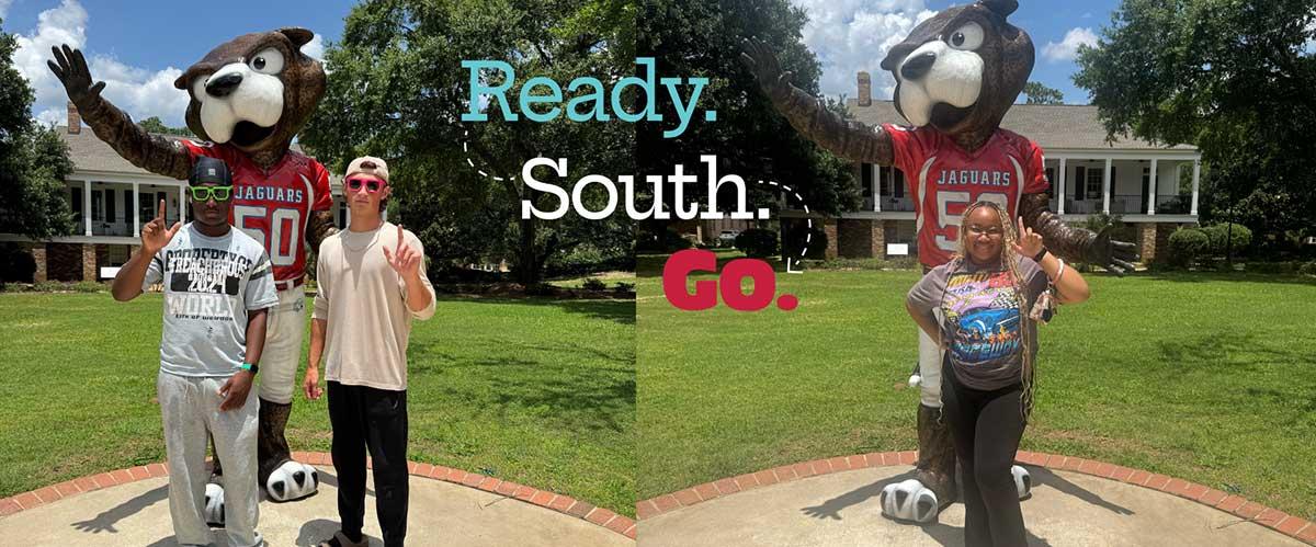 South Alabama Students posing in front of the South Paw statue on campus