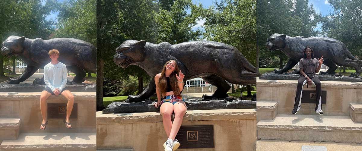 South Alabama students throwing up the J in front of the Jaguar statue at the Mitchel Center