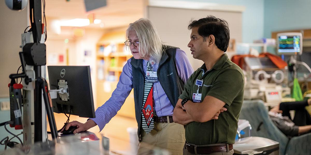 NICU Doctors consulting looking at computer.