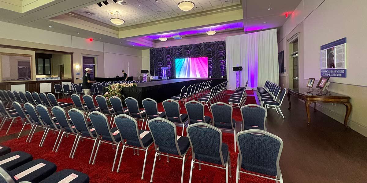 Room set with chairs surrounding long stage 