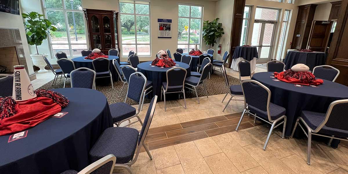 Room with tables set with football themed centerpieces 