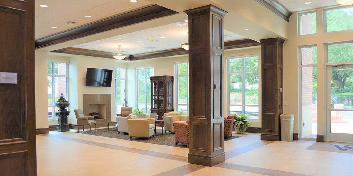 A view of the grand lobby showing seating area, fireplace, and tv.