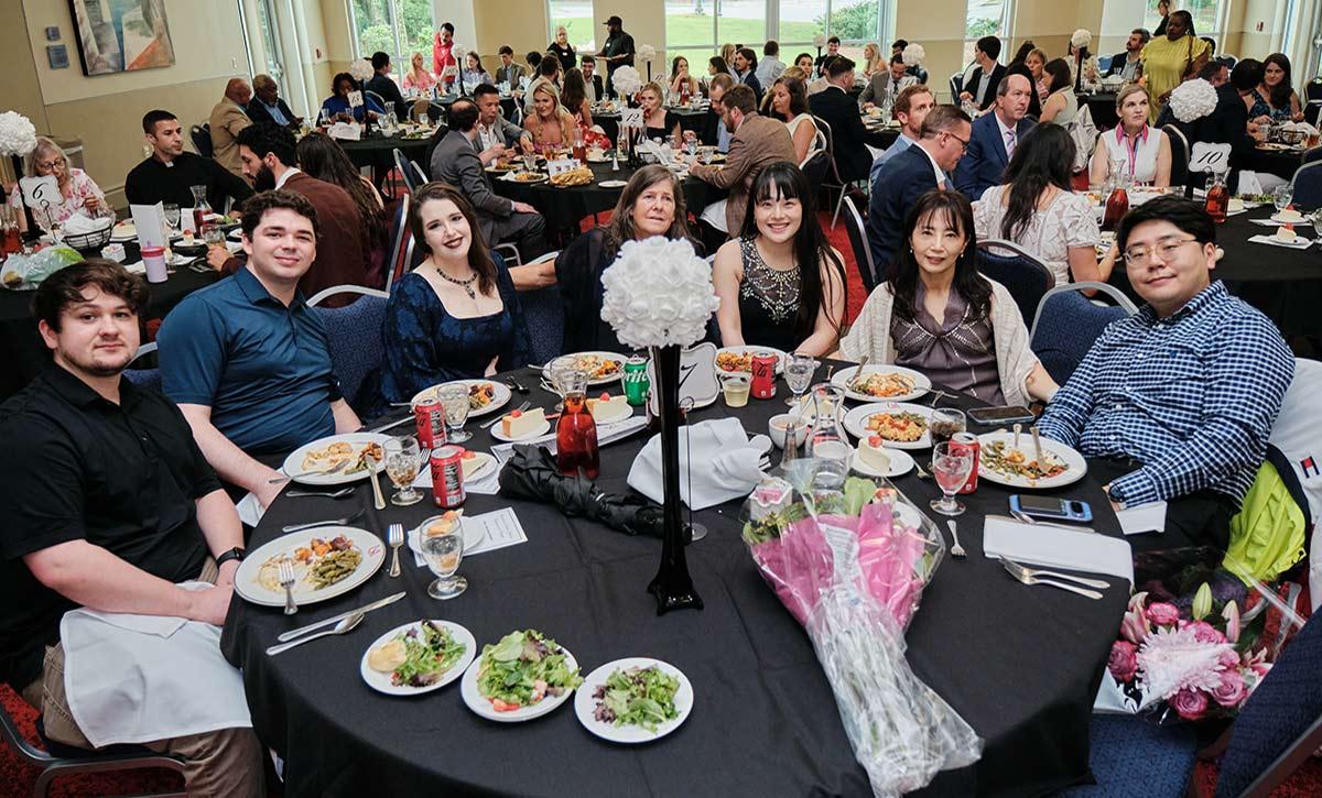 Group picture at table eating.