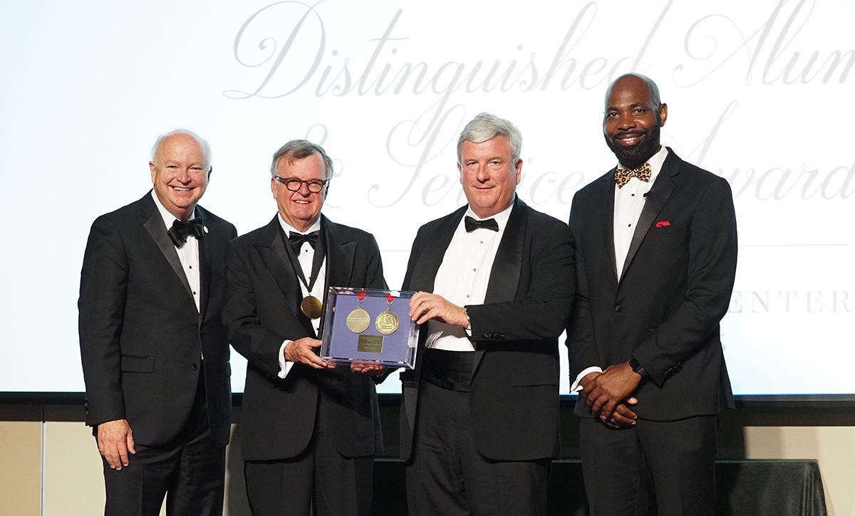 Distinguished Alumni award recipients on stage.