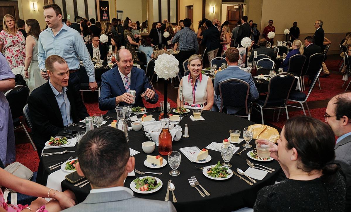 People talking at tables during event.
