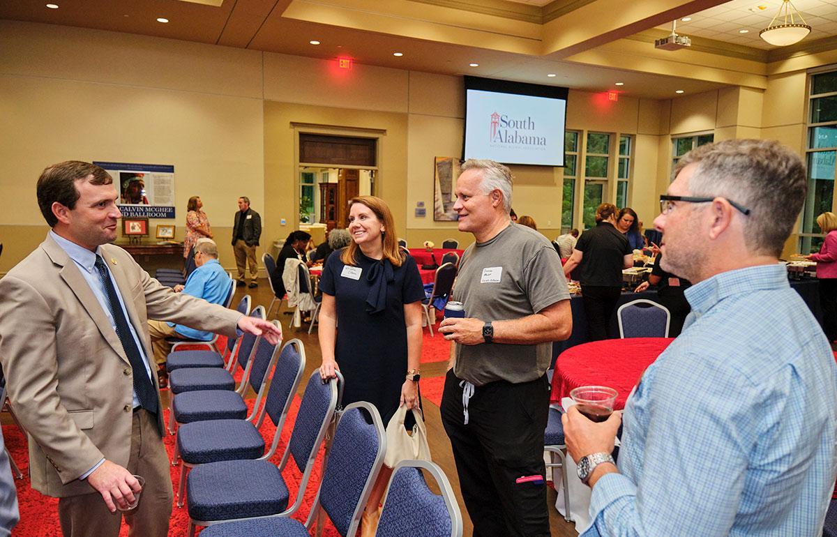 National Alumni Association meeting with Peter Susman and Kristin Odom speaking with two other people.