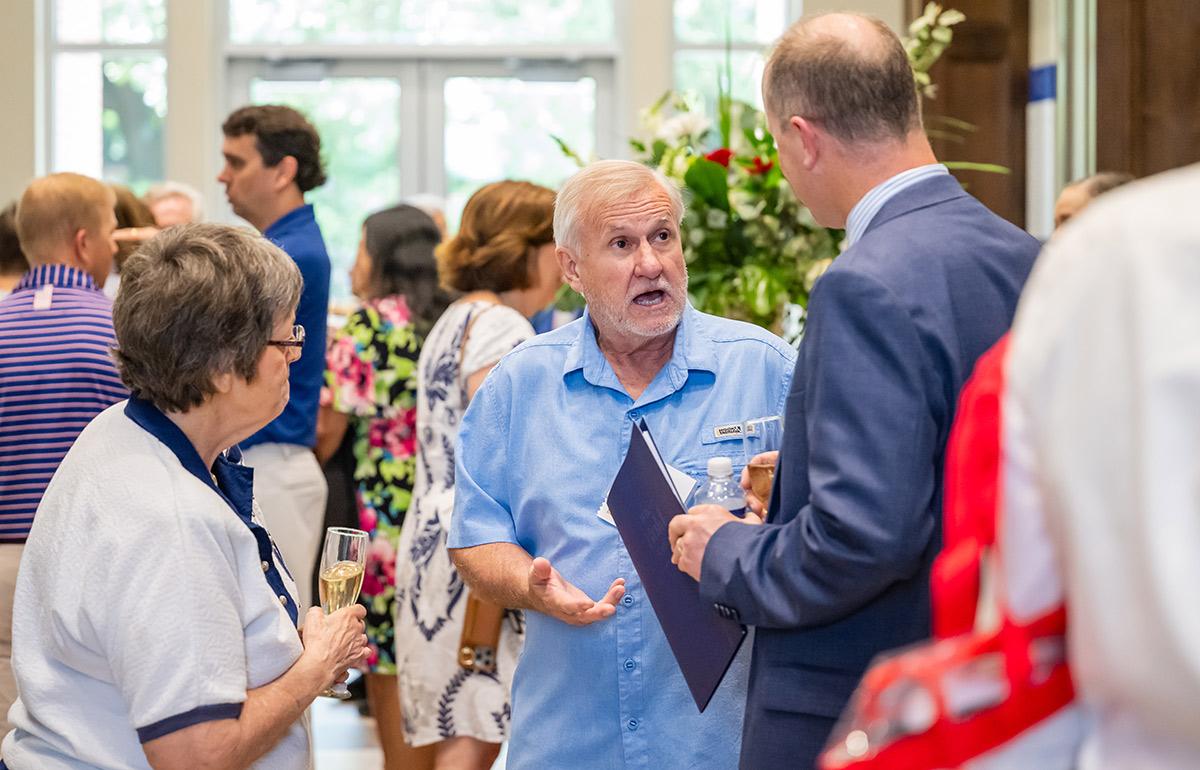 Three people speaking at the Medical Alumni Association event.