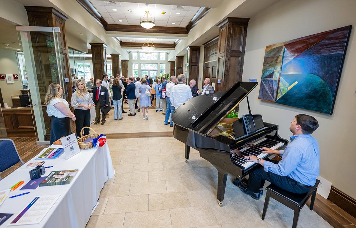 Person playing the piano at Medical Alumni Association event.