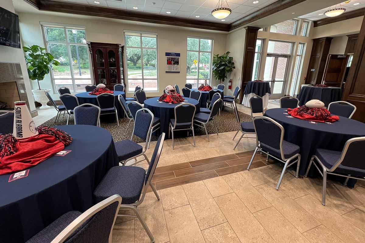 Tables set with blue tablecloths and football / south gear