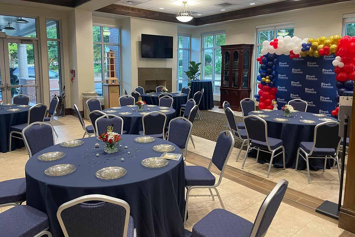 Tables set with blue tablecloths and south themed balloon arch photo area