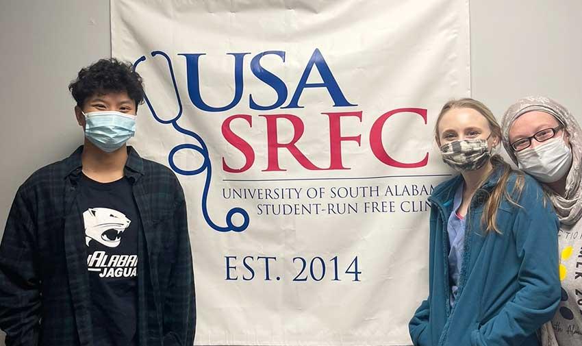 SRFC volunteers standing in front of banner.