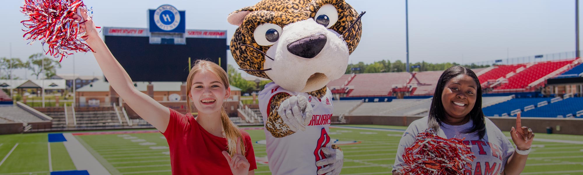 Two female students with South Paw in Hancock Whitney Stadium
