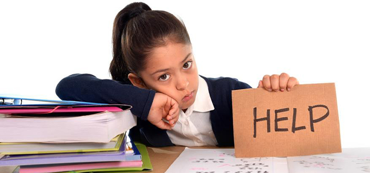 Young girl at desk with books and paper holding a sign that reads Help