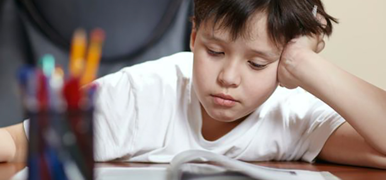 Young child reading at desk