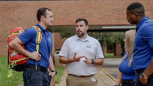 Joshuar Coaker speaking to EMS students outside.