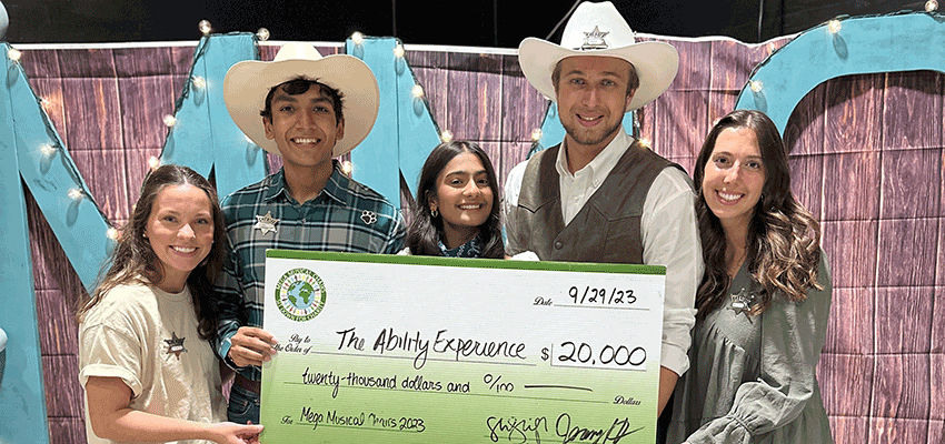 Students presenting check at Mega Musical Chairs. data-lightbox='featured'