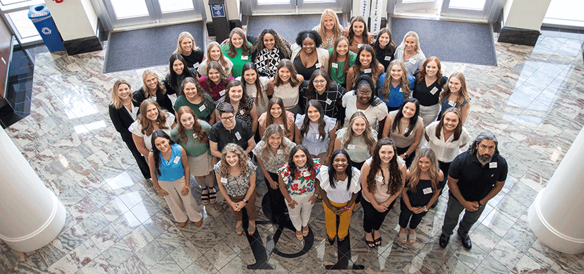 Doctor of Occupational Therapy first class standing inside of Allied Health building.
