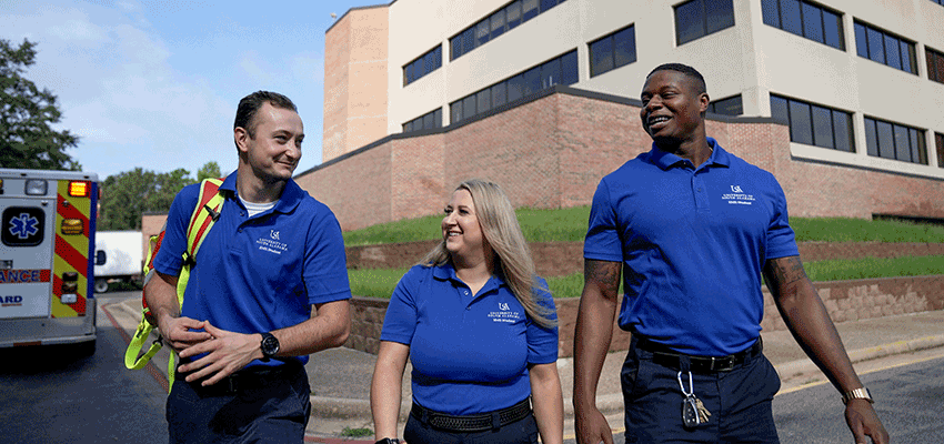 Three Emergency Medical Services students walking outside of the Allied Health Building.